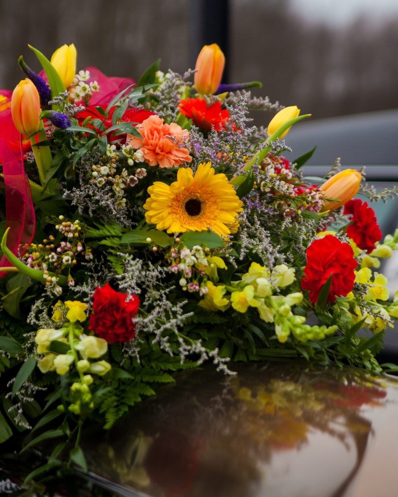Funeral Casket and flowers next to hearse
