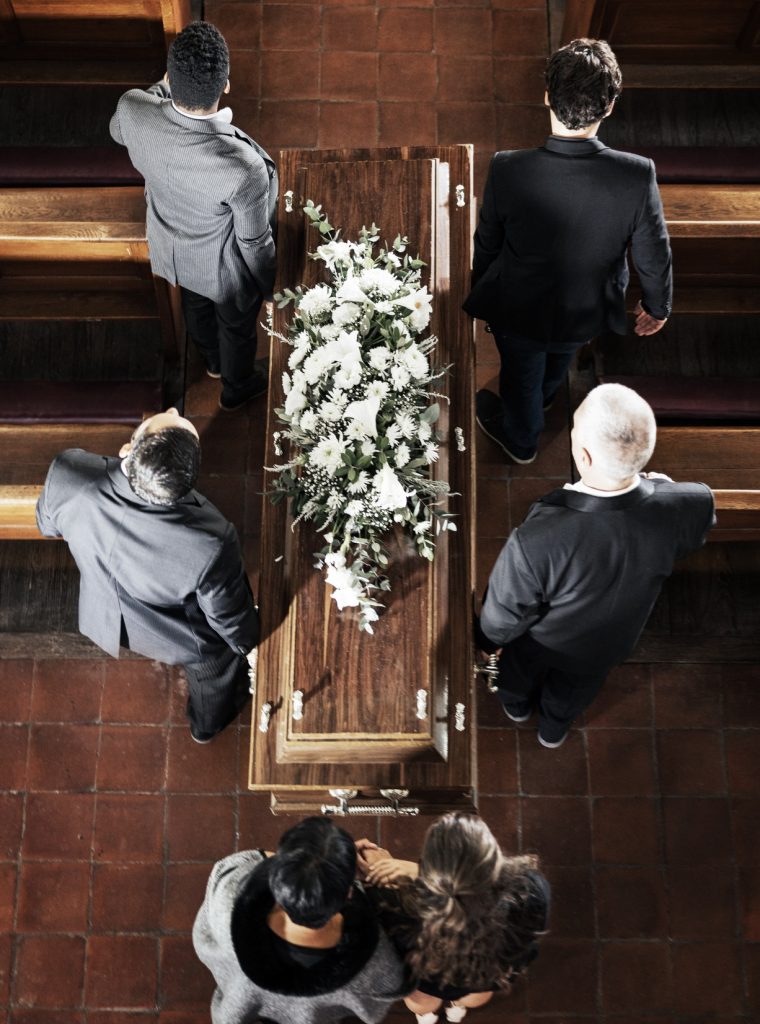Funeral, coffin and family mourning death of loved one, death and carrying wood casket in church fo